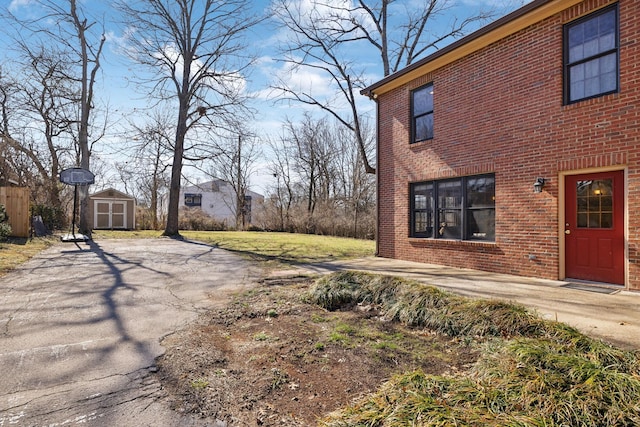 exterior space with an outbuilding, a shed, and brick siding