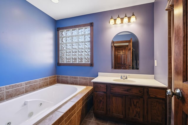 bathroom with a tub with jets and vanity