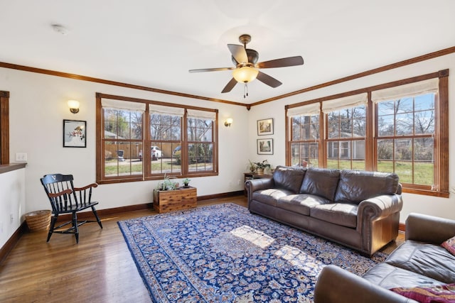 living area with a ceiling fan, crown molding, baseboards, and wood finished floors