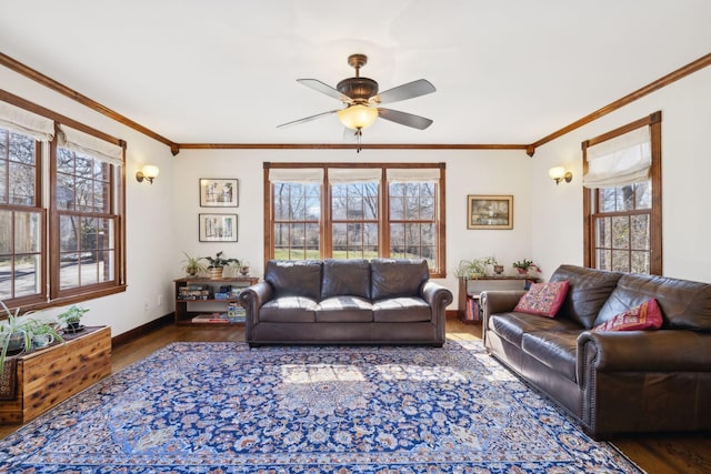 living area with crown molding, wood finished floors, baseboards, and ceiling fan