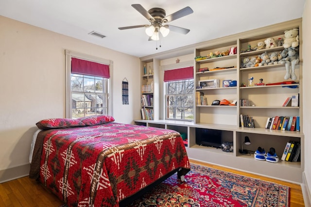 bedroom featuring visible vents, a ceiling fan, and wood finished floors