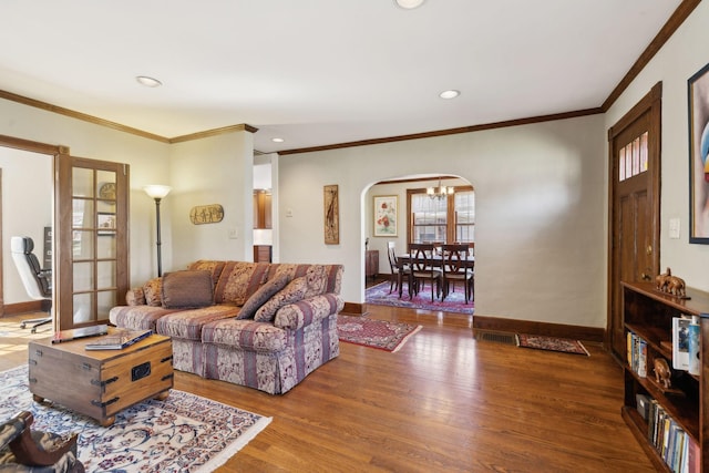 living room featuring wood finished floors, recessed lighting, arched walkways, crown molding, and baseboards