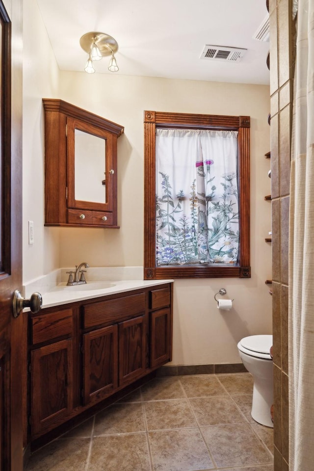 bathroom with tile patterned flooring, visible vents, baseboards, toilet, and vanity