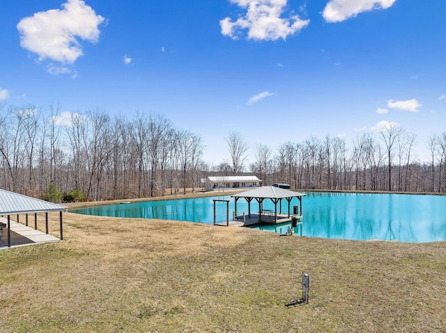 view of pool featuring boat lift, a lawn, and a dock