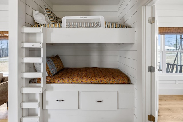 unfurnished bedroom featuring wood finished floors and wood walls