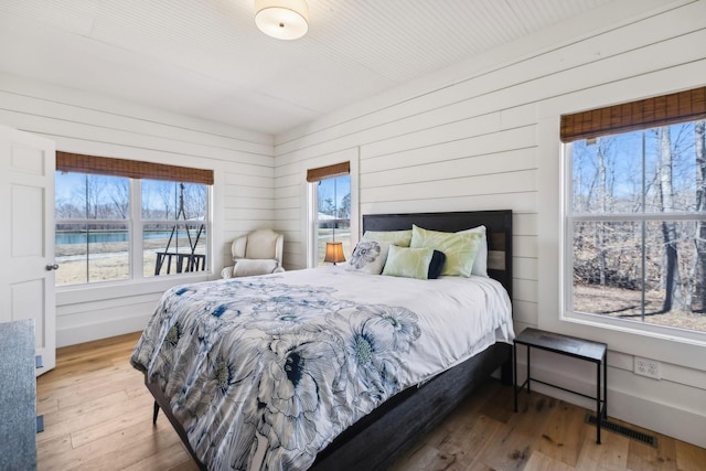 bedroom featuring visible vents, baseboards, and wood finished floors