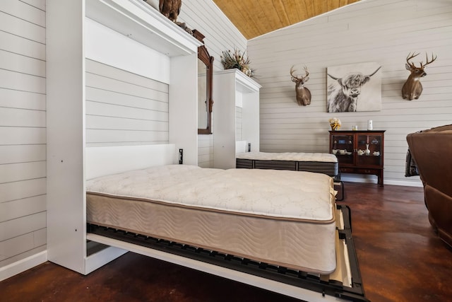 bedroom with wood ceiling, finished concrete flooring, and vaulted ceiling