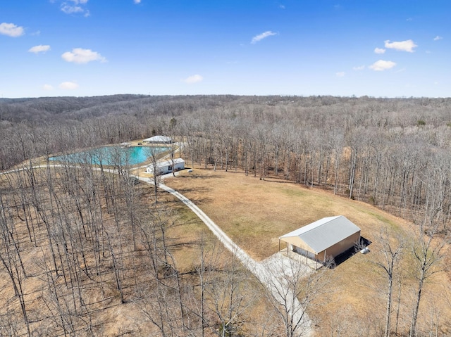 drone / aerial view featuring a view of trees and a water view