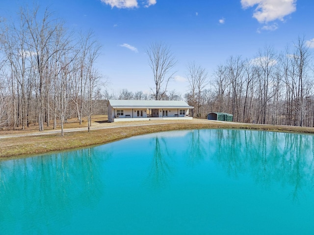 view of pool featuring an outbuilding, covered porch, and a lawn