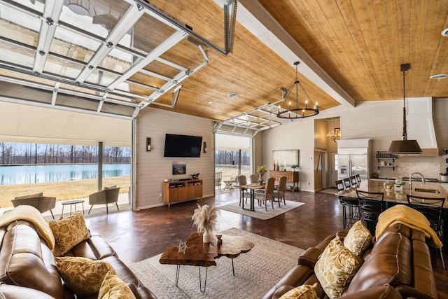 living area featuring wooden ceiling, a notable chandelier, concrete floors, and vaulted ceiling with beams