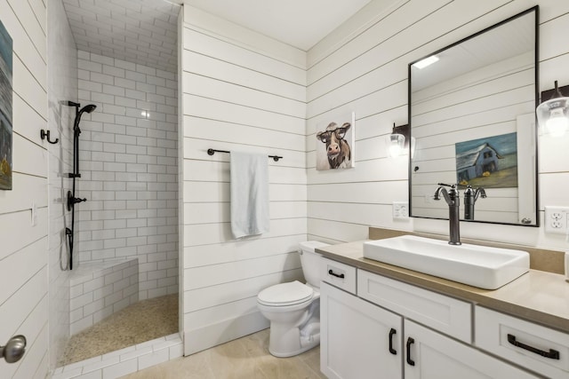 bathroom featuring wooden walls, toilet, vanity, and walk in shower