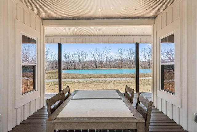 unfurnished sunroom featuring a water view