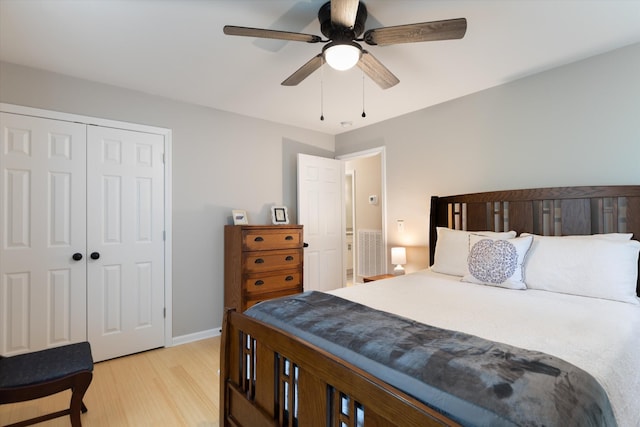 bedroom with light wood finished floors, baseboards, a ceiling fan, and a closet