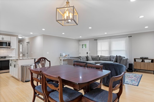 dining room featuring recessed lighting, light wood-style flooring, and crown molding