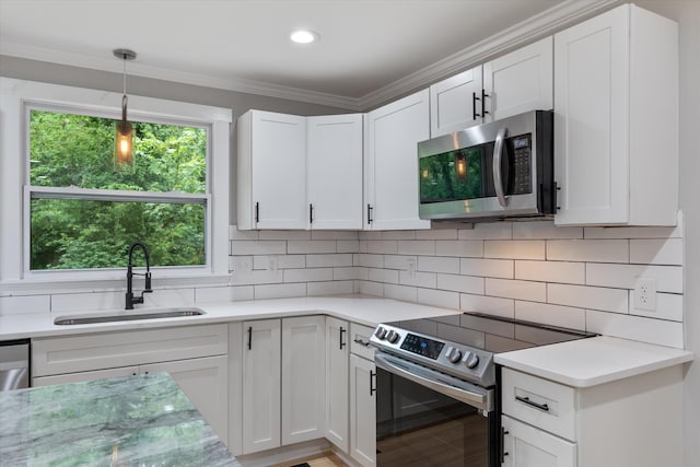 kitchen featuring decorative backsplash, stainless steel appliances, light countertops, and a sink