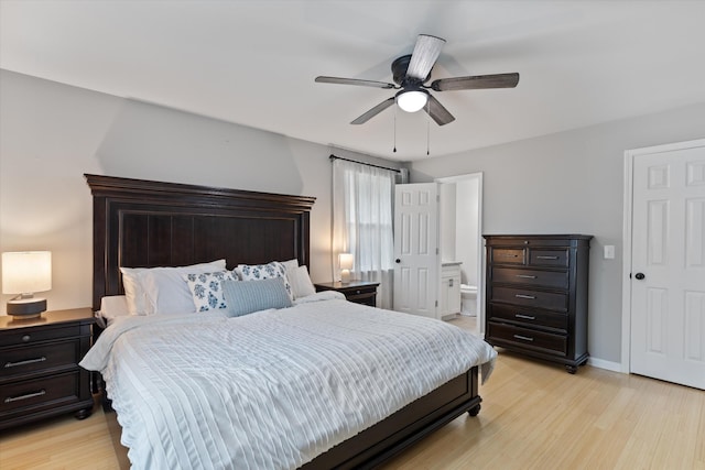 bedroom with ensuite bath, ceiling fan, baseboards, and light wood-style floors