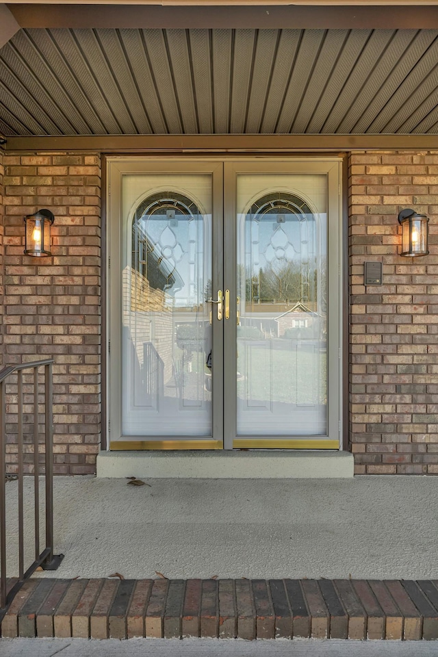 doorway to property with brick siding and covered porch