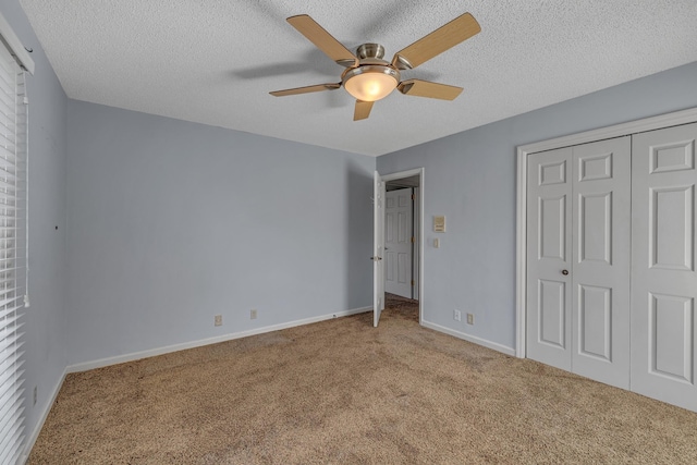 unfurnished bedroom with ceiling fan, baseboards, carpet floors, a closet, and a textured ceiling