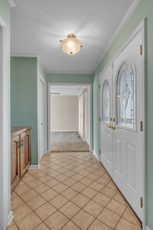 foyer entrance featuring french doors, a textured ceiling, light tile patterned flooring, and crown molding