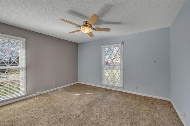 spare room featuring baseboards, plenty of natural light, and carpet flooring