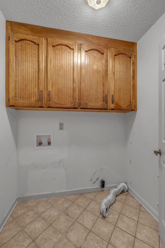 laundry room with baseboards, light tile patterned floors, hookup for a washing machine, cabinet space, and a textured ceiling