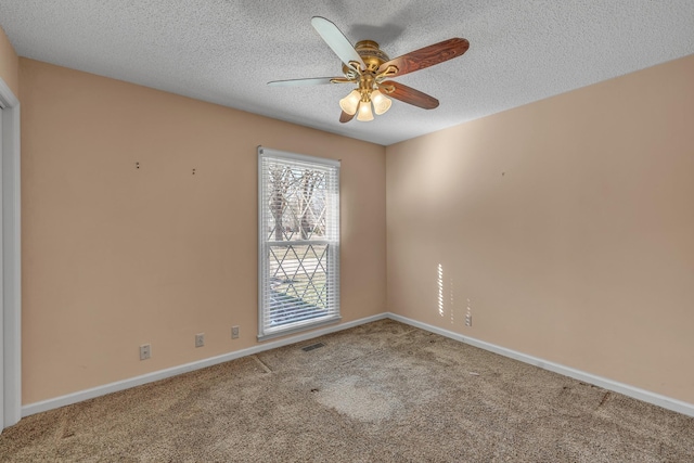 carpeted spare room featuring visible vents, baseboards, a textured ceiling, and ceiling fan