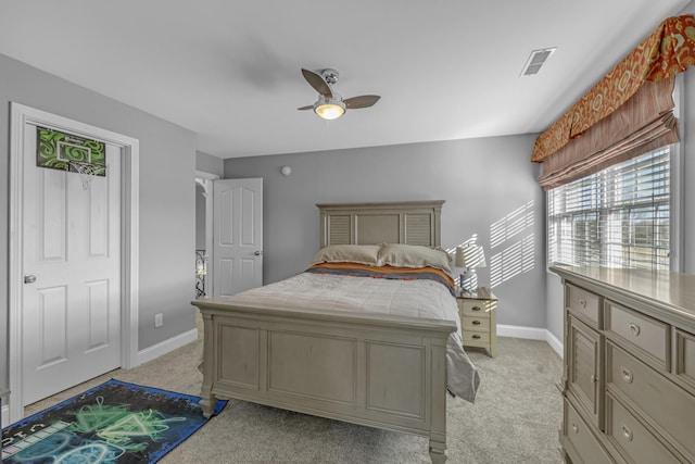 bedroom with a ceiling fan, visible vents, baseboards, and light carpet