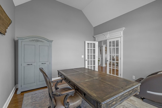 office with baseboards, high vaulted ceiling, and wood finished floors