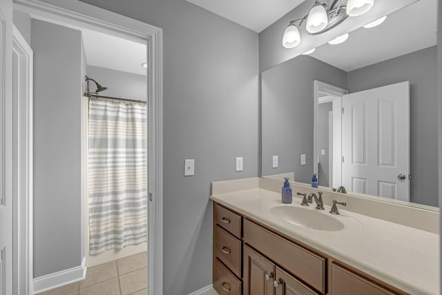 bathroom featuring vanity, tile patterned floors, curtained shower, and baseboards