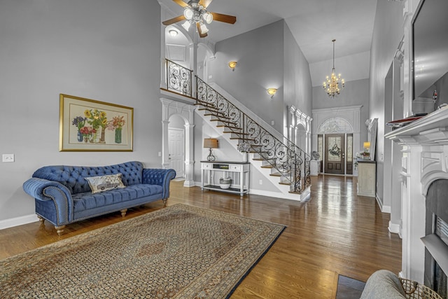 living area featuring wood finished floors, stairway, a fireplace, and baseboards