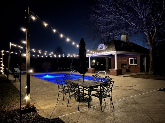 pool at twilight with a fenced in pool, a patio, and outdoor dining space