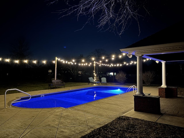 pool at twilight with a patio area, an outdoor pool, and a fenced backyard