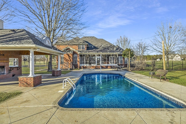 view of swimming pool featuring a fenced in pool, an outdoor brick fireplace, fence, a sunroom, and a patio area