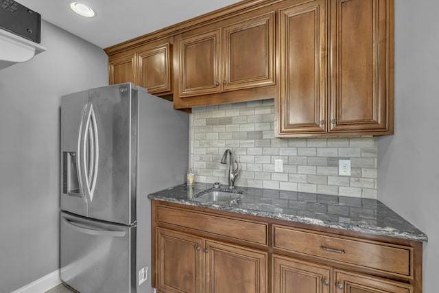 kitchen featuring brown cabinets, stainless steel fridge with ice dispenser, and a sink