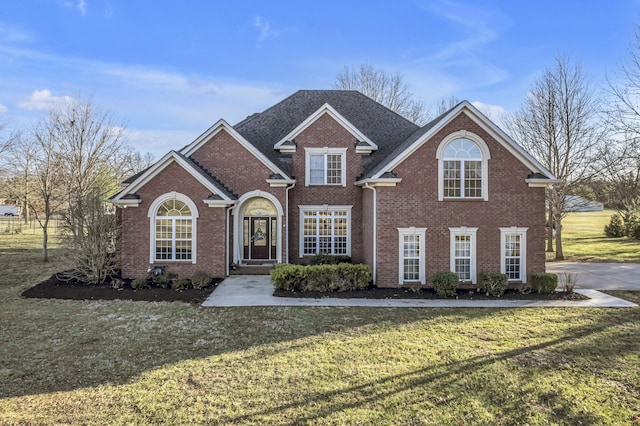 traditional-style home with brick siding and a front yard