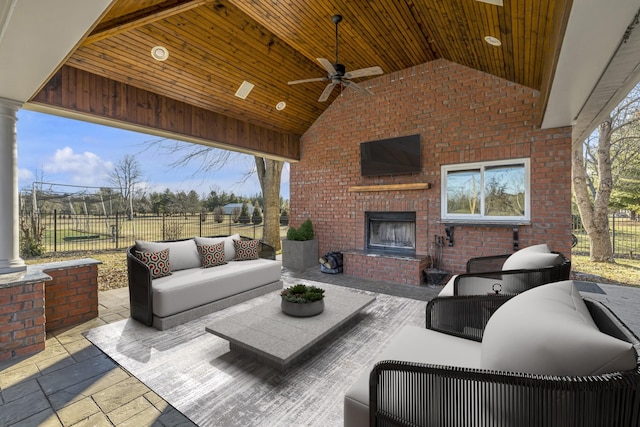 view of patio featuring fence, a ceiling fan, and an outdoor living space with a fireplace