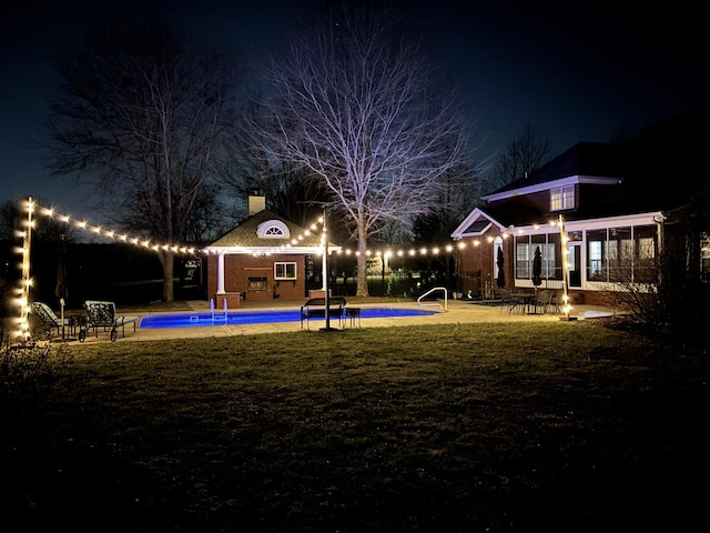 yard at night with an outdoor pool