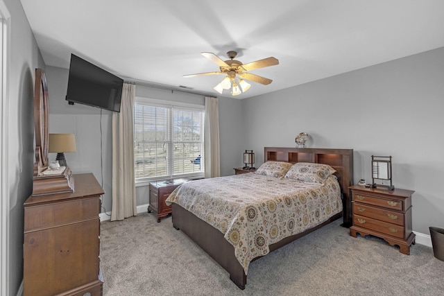 bedroom featuring light carpet, ceiling fan, and baseboards