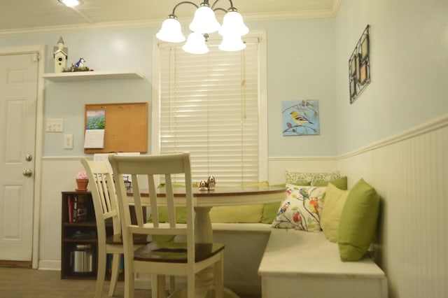 dining room featuring an inviting chandelier, ornamental molding, and wainscoting