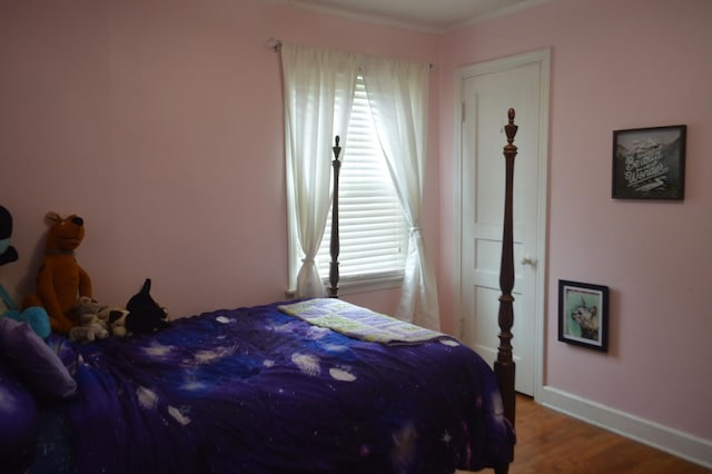 bedroom with baseboards and wood finished floors