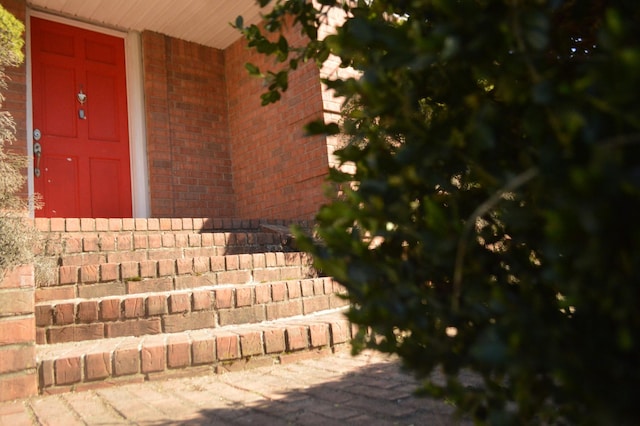 doorway to property featuring brick siding