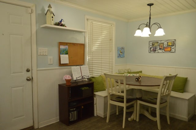 dining area with crown molding, dark wood-style floors, a chandelier, and wainscoting