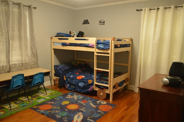 bedroom with crown molding and wood finished floors