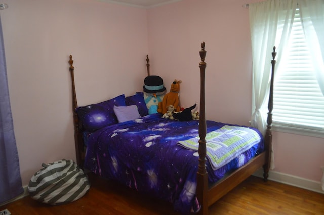 bedroom featuring baseboards and wood finished floors