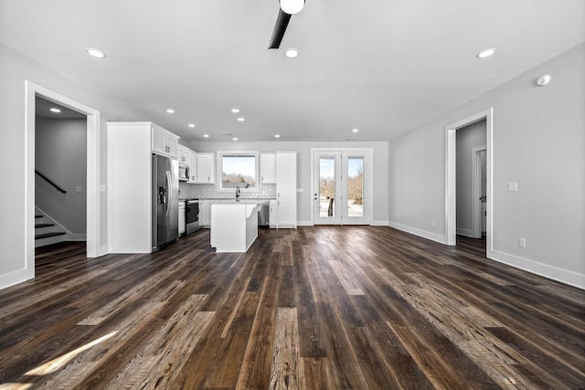 unfurnished living room with baseboards, stairs, recessed lighting, french doors, and dark wood-style flooring