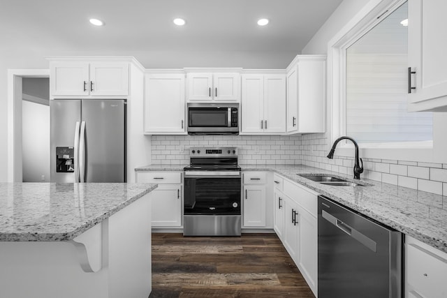 kitchen featuring a sink, white cabinets, dark wood finished floors, and stainless steel appliances