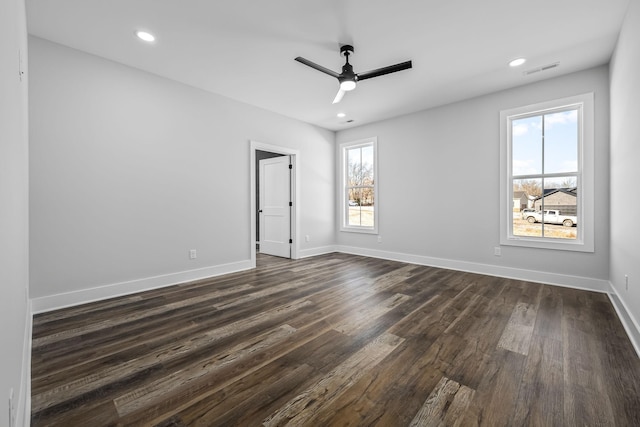 unfurnished room featuring visible vents, baseboards, ceiling fan, and dark wood-style flooring