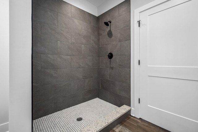 full bathroom with a stall shower and wood finished floors