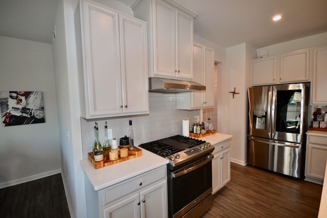 kitchen with tasteful backsplash, under cabinet range hood, dark wood finished floors, light countertops, and appliances with stainless steel finishes