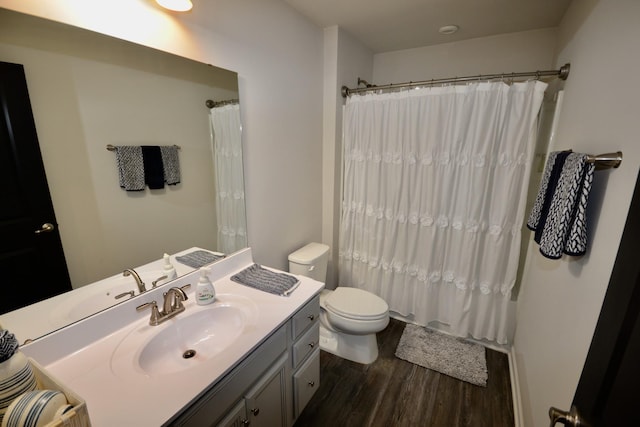 bathroom featuring a shower with curtain, toilet, wood finished floors, and vanity